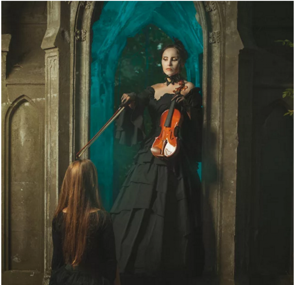 Women points violin bow at girl on her knees in a castle